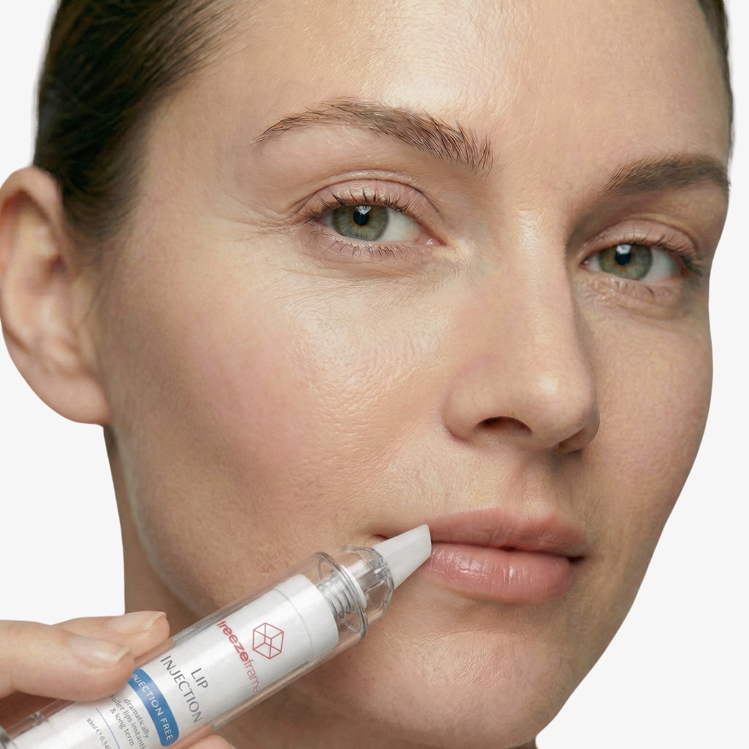 freezeframe LIP INJECTION needle-free lip plumping treatment held against a woman's lips, showing the precision applicator designed for targeted application.